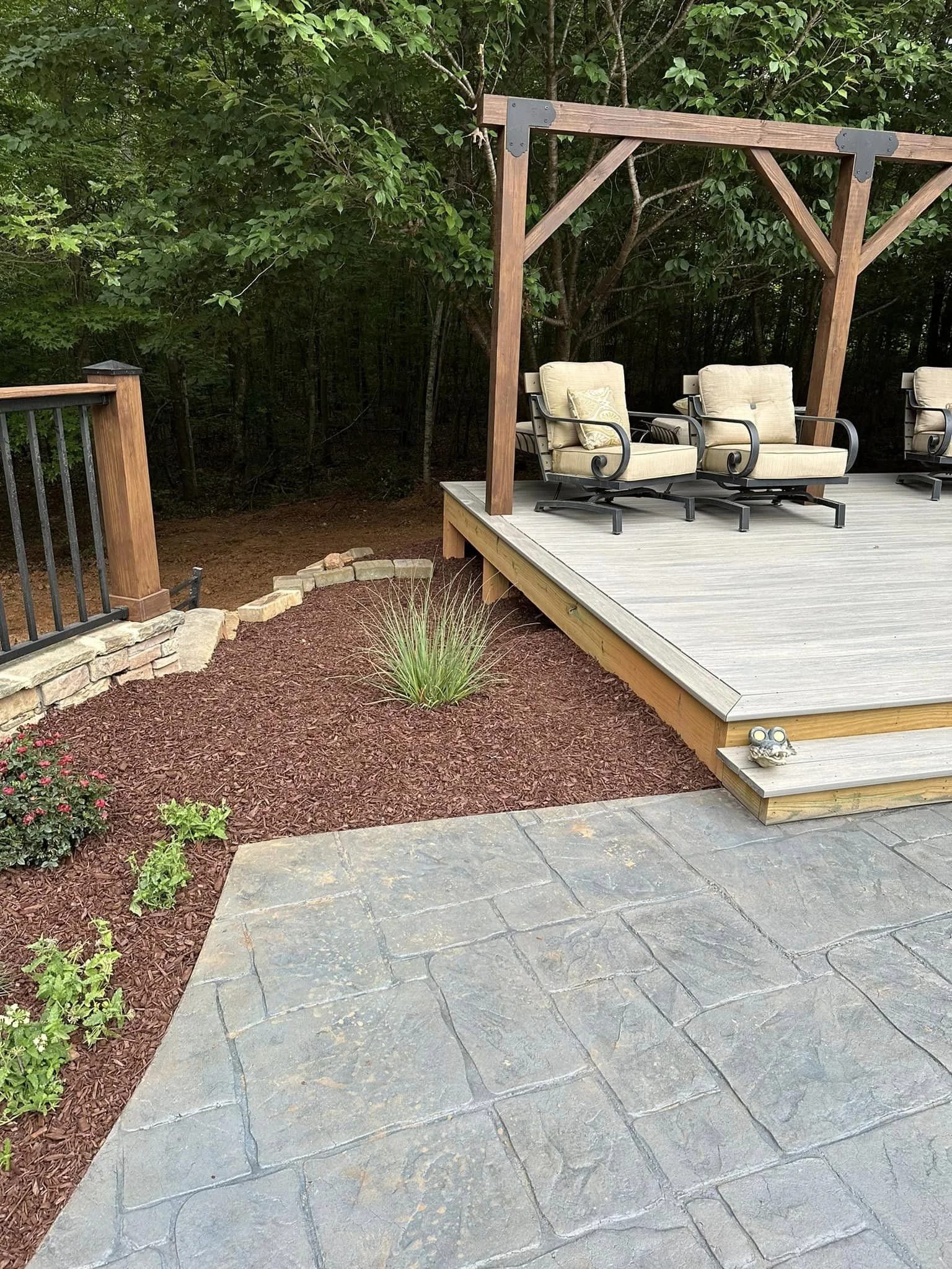 Mulched landscaping bed near a deck and pergola